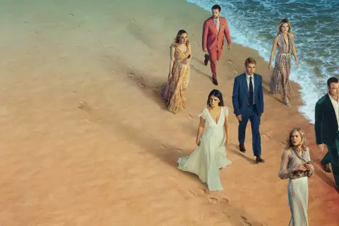 En grupp människor i eleganta kläder på en strand. Kanske är de det perfekta paret, eller så döljer de en hemlighet.