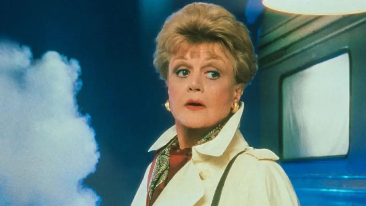 Jessica Fletcher, i rollistan i Mord och inga visor, ser fundersam ut med en vit trenchcoat och en mönstrad scarf.