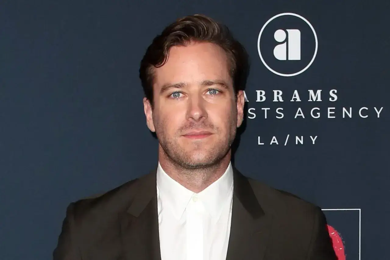 Armie Hammer, med blå ögon och mörkt hår, bär en mörk kavaj och vit skjorta. Bakgrunden visar en logotyp för Abrams Artists Agency.
