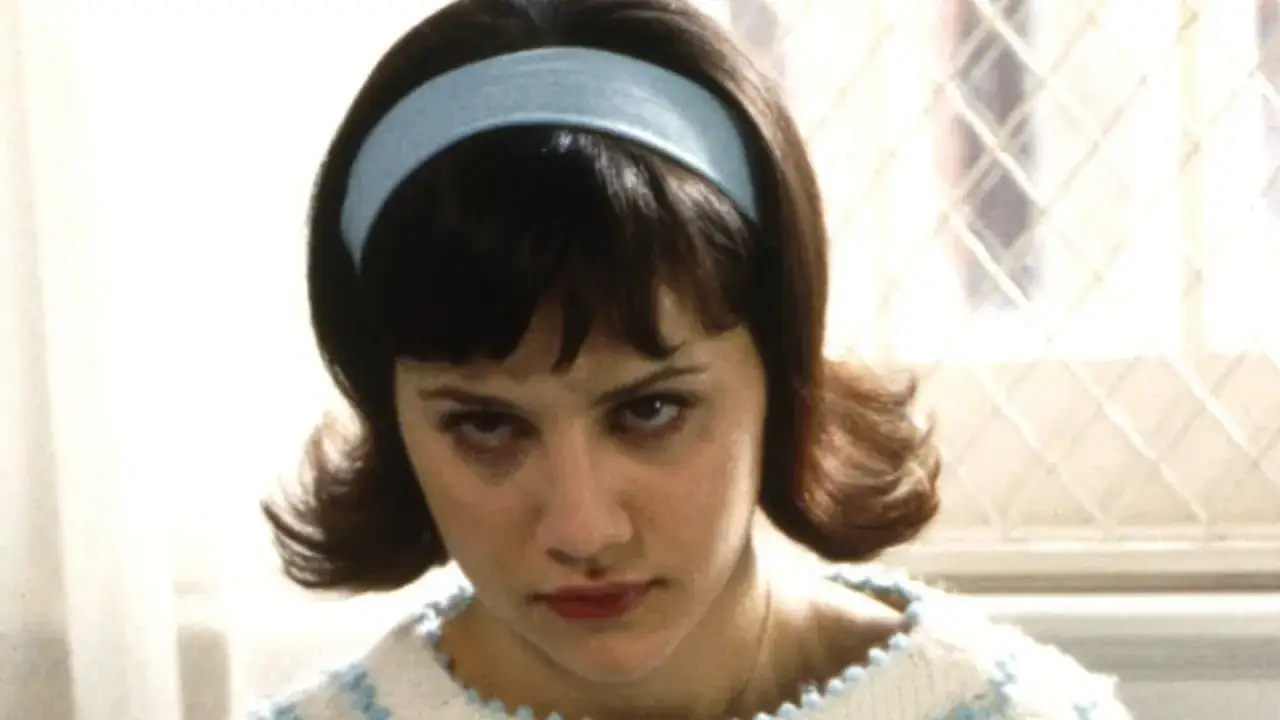 Brittany Murphy med bl&aring;tt pannband och stickad tr&ouml;ja, en ikonisk scen fr&aring;n hennes filmer.